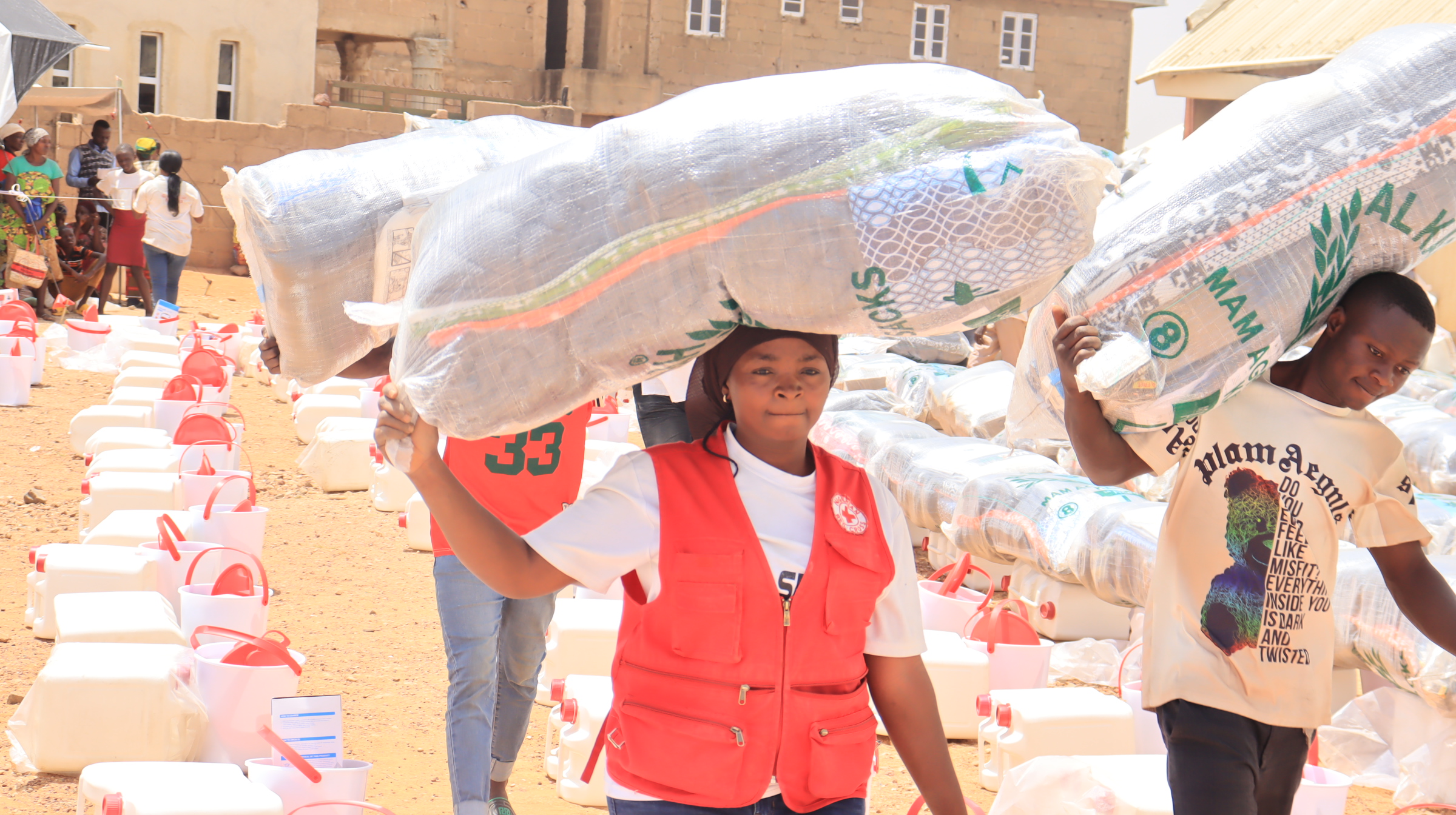 Red Cross volunteer lifts relief material at the distribution site at Bokkos, LGA, Plateau State, Nigeria- Photo Credit-Chima Nwankwo